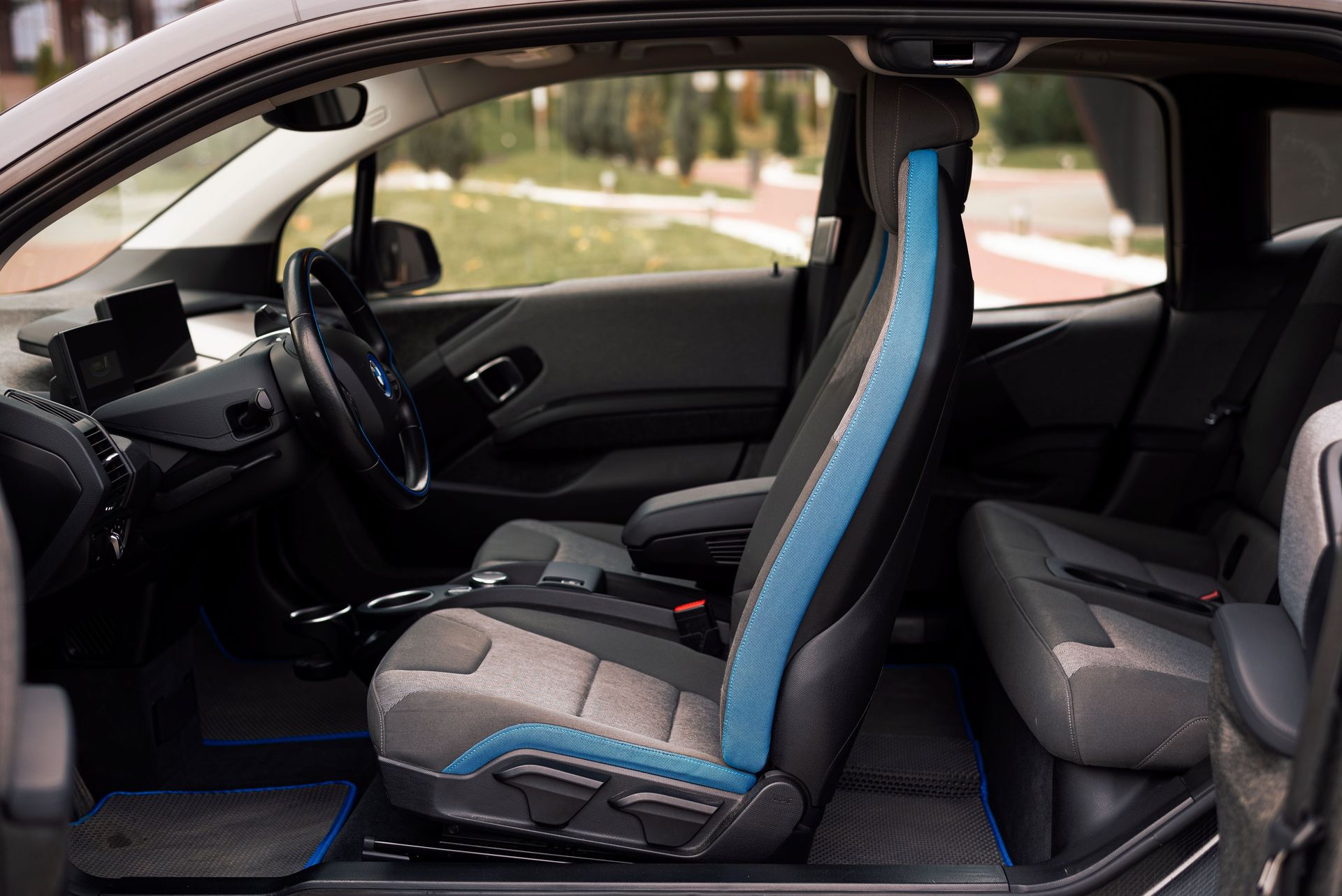 A sleek interior of a modern car showcasing the front and rear seats and steering wheel details.