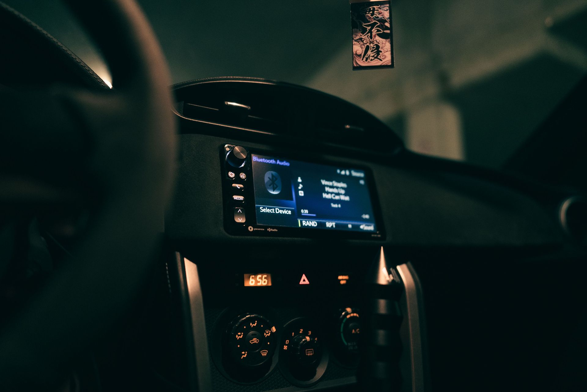 Car dashboard showing an audio system display in a dimly lit interior, focusing on technology.